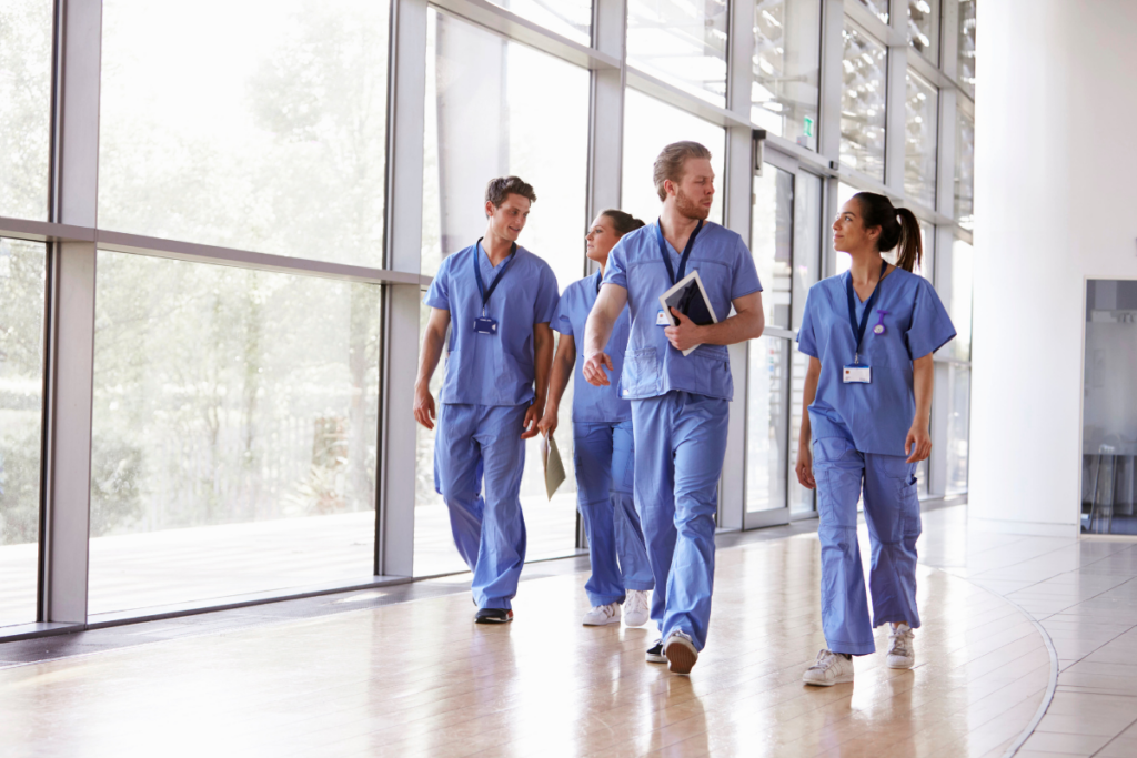 Group of people in scrubs walking and talking