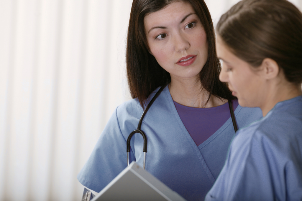 Two women in scrubs talking